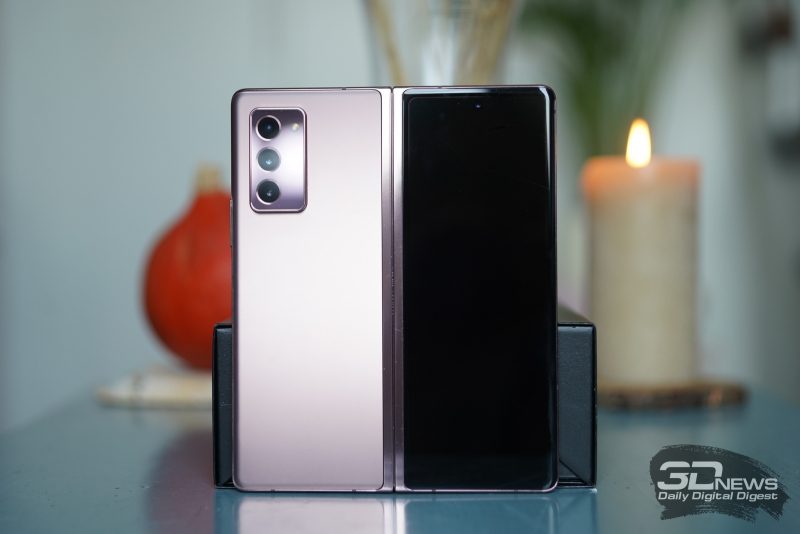 Samsung Galaxy Z Fold2, внешняя поверхность: на одной половине — блок с тремя камерами и одинарной светодиодной вспышкой, на второй — экран с идентичным отверстием для фронтальной камеры и тонкая прорезь разговорного динамика сверху